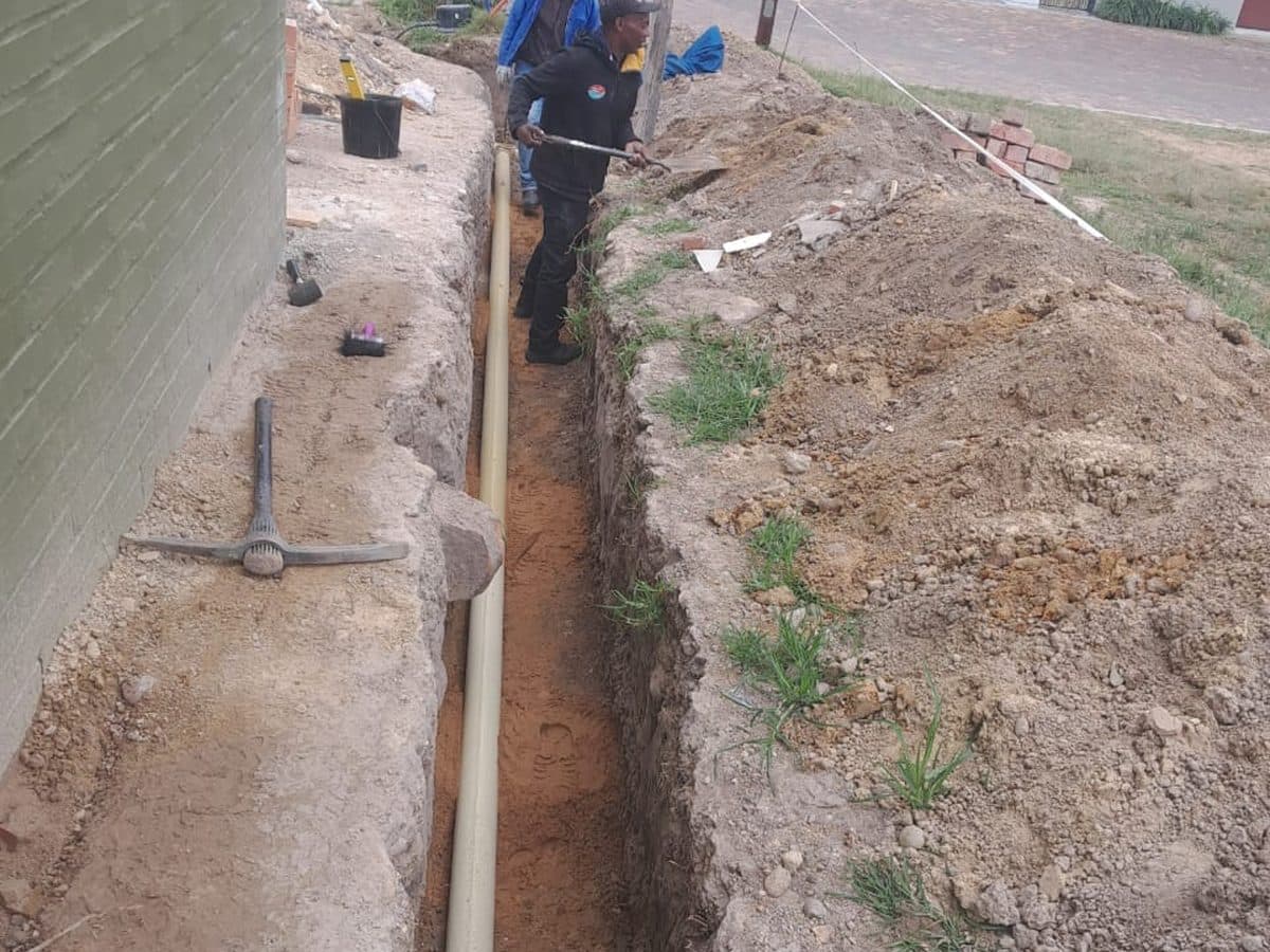 Open drain trench with the new pipe laid in it