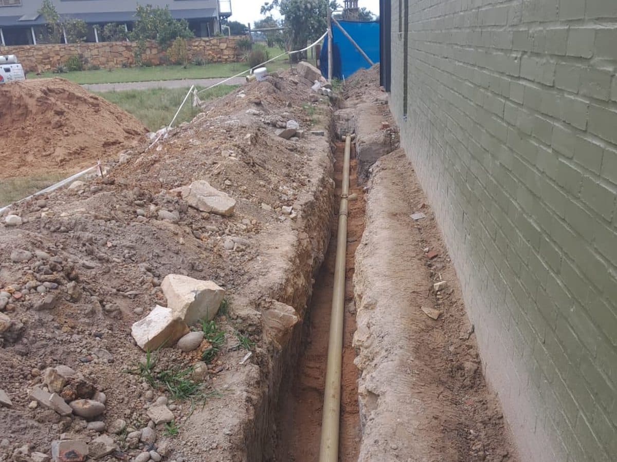 Drain line laid in a trench below the paving