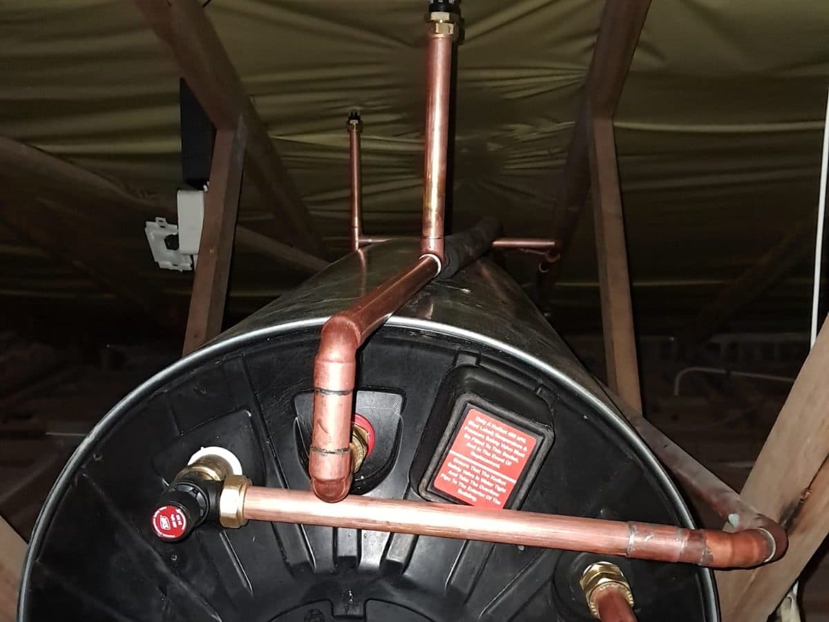 Geyser cylinder connected to copper pipes in a roof void
