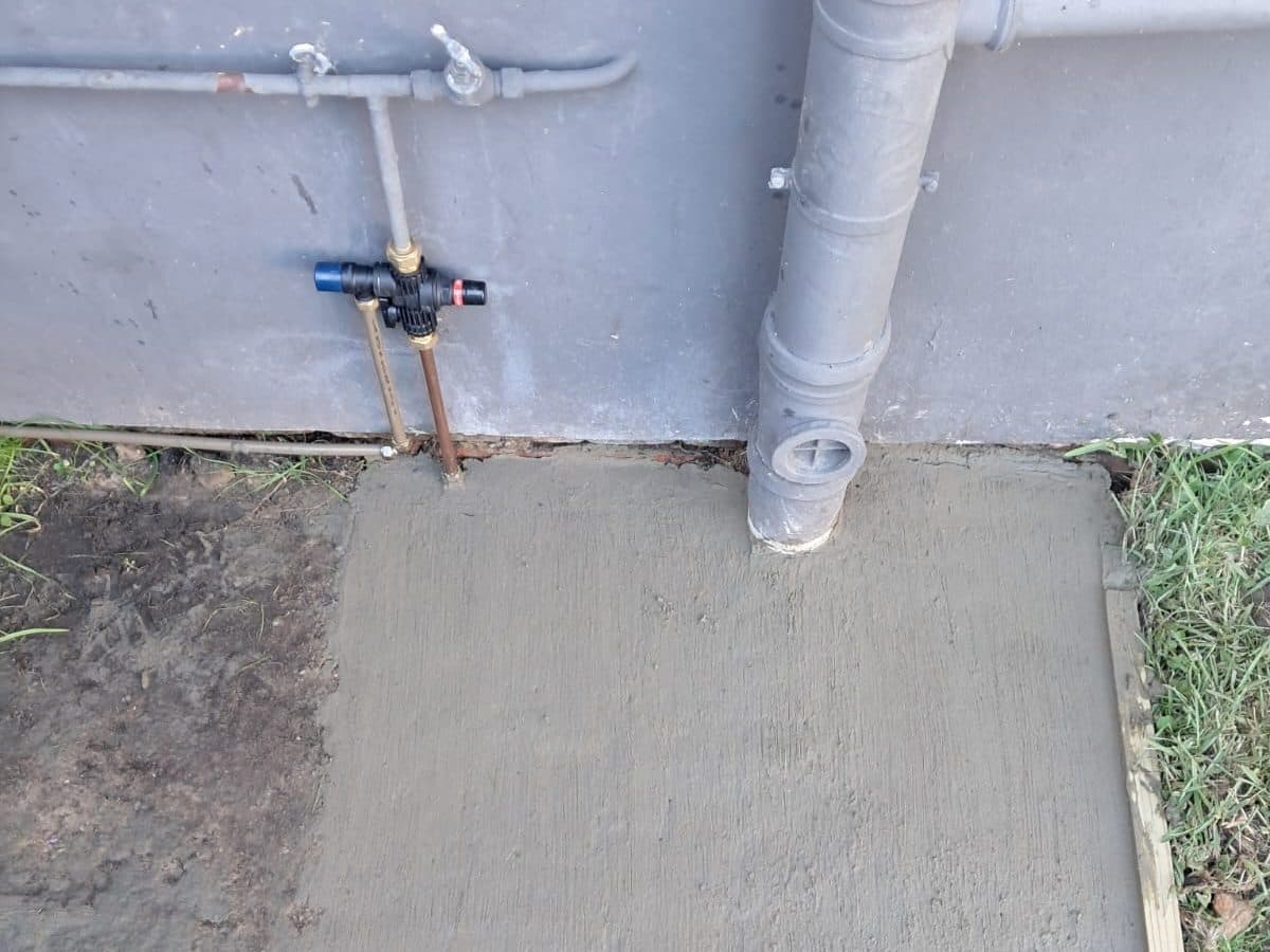 Pipe and valve at the base of a wall