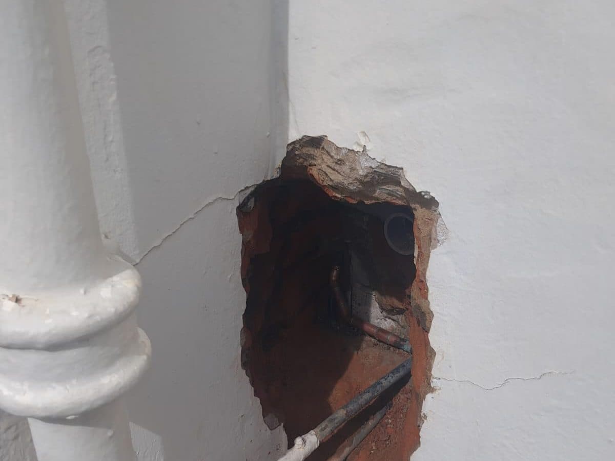 Burst pipe exposed in an opened-up wall