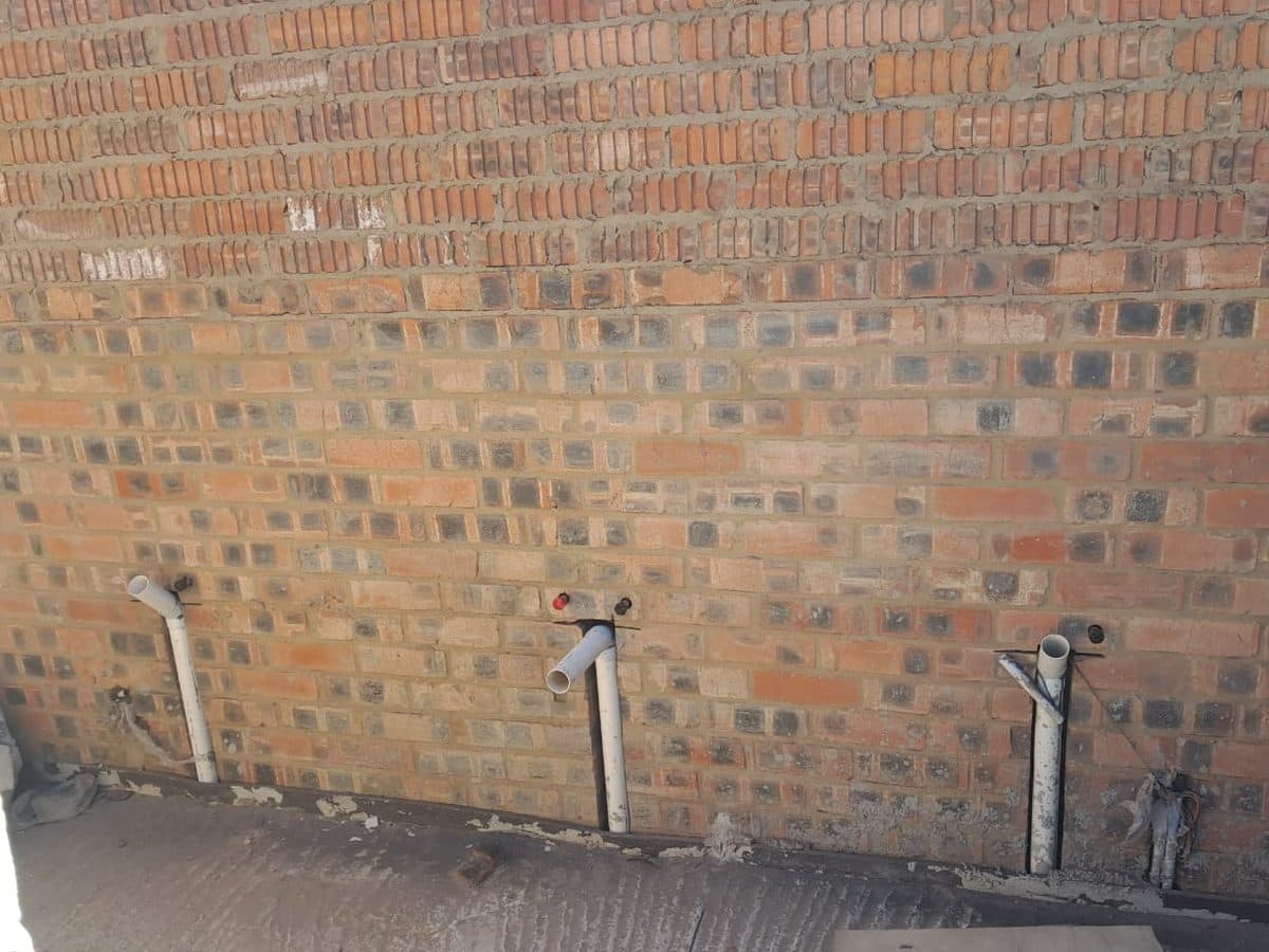 Tap points and water meters fitted on a brick wall