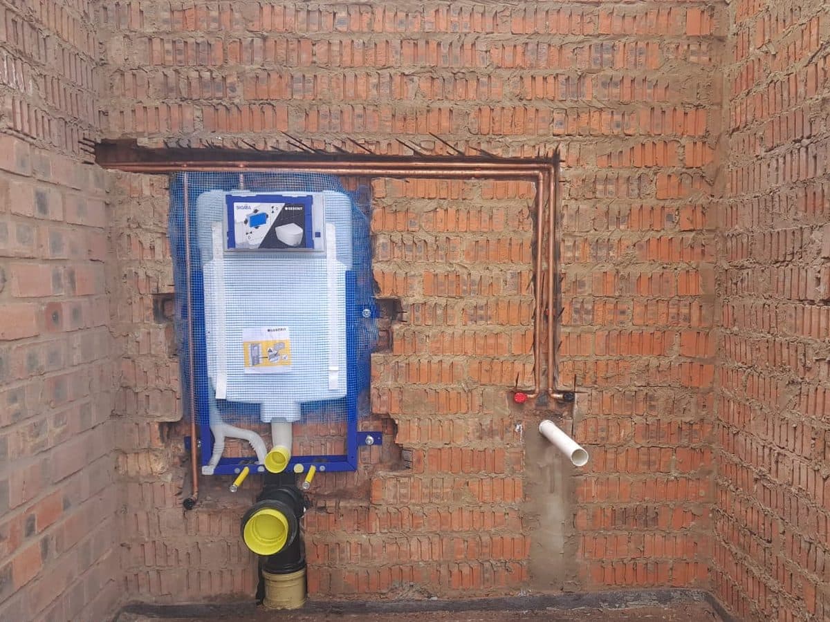 Water meter and pipework on a brick wall