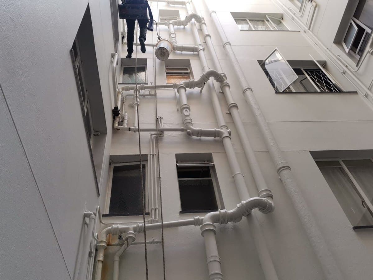 Plumbing work on a multi-storey complex requiring access equipment